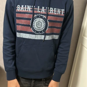 Mörkblå Saint Laurent hoodie - I NYSKICK! Säljer/Byter för en i storlek M, Modellen är 170cm lång och den sitter ganska tajt