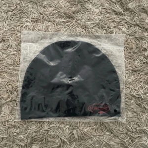 Starlight mössa - Svart mössa från Starlight med enkel och clean design. På framsidan finns ett rött broderat Starlight-logo med en liten stjärna. Mössan har rundad form och är tillverkad i mjukt material som passar perfekt för kyliga dagar.