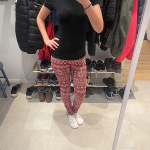Röda leggings  - Röda leggings med  hjärtan och zigzag-mönster. Stretchigt material som sitter tight och är perfekta för mysiga kalla dagar. mjuk känsla, passar dig som vill ha något bekvämt och snyggt till vintern. Storleken är mellan S-XS