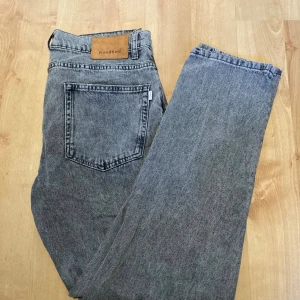 Grå jeans från Woodbird i rak modell - Säljer ett par grå jeans från Woodbird i rak passform. Jeansen är tillverkade i ekologisk bomull och har klassisk femficksdesign, dragkedja och knapp framtill. Snygg tvättad grå färg som passar till det mesta. Perfekta för dig som gillar en clean och stilren look. Bilder och Mått finns om du vill ha. W32 L32