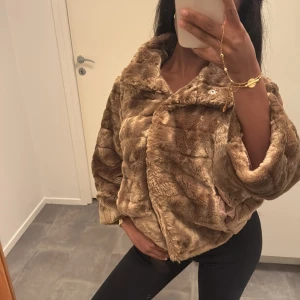 Trekvartsärmad pälsjacka - Supermjuk och fluffig beige/brun trekvartsärmad pälsjacka med bred krage och stora knappar framtill. Jackan har en loose passform och är perfekt för dig som vill ha en mysig och trendig look 😍🍂