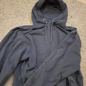 Mörkblå hoodie från 157 med huva - Säljer en  mörkblå hoodie från 157 i storlek S. Tröjan har huva med snörning och långa ärmar.