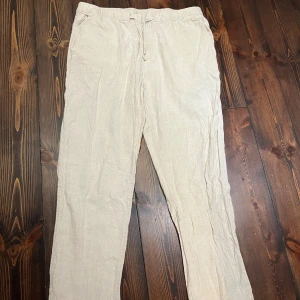 Beiga linnebyxor från H&M Regular Fit - Snygga och luftiga creme vita linnebyxor från H&M i regular fit. Storlek L. Nypris 350 kr