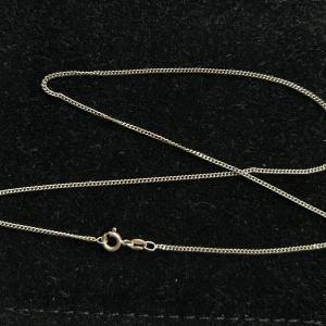 Tunt silverhalsband med karbinlås 925 - Snyggt och stilrent halsband i äkta silver med tunn kedja och klassiskt karbinlås. Perfekt att bära som det är eller kombinera med ett hängsmycke. Enkel och tidlös design som passar till många olika stilar. 42cm