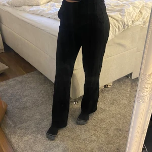 Svarta kostymbyxor från Vero Moda - Snygga svarta kostymbyxor från Vero Moda med midwaste och raka ben. Byxorna har bälteshällor, knapp och dragkedja fram samt sidfickor. Perfekt till en chill och stilren look. Materialet är mjukt och har en lätt stretch.