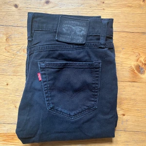 Svarta Levi's 511 jeans - Säljer ett par svarta Levi's 511 jeans. Jeansen har en slim passform och raka ben, tillverkade i mjukt bomullstyg med lite stretch för extra komfort. Priset är inte hugget i sten vid snabb affär! W30 L34