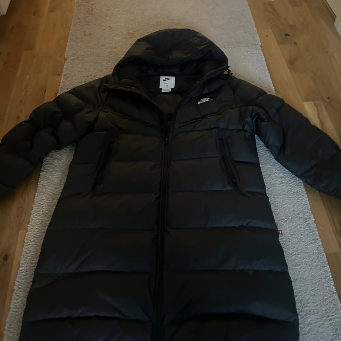 Svart lång pufferjacka från Nike - 1