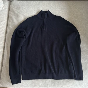 Blå stickad half zip-tröja - Blå stickad tröja från Lindex med half zip och hög krage. Tröjan har lång ärm och är i en klassisk, enkel modell som passar perfekt till lager-på-lager. Materialet är mjukt och ribbat för extra komfort. Passar dig som är runt 170cm motsvarar s