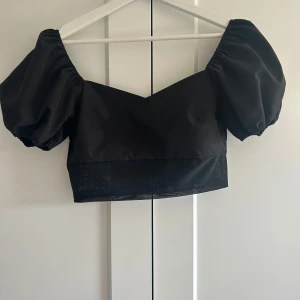 Svart croppad topp - Säljer en svart cropped topp med puff ärmar. 