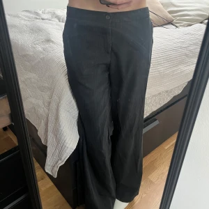 Randiga kostymbyxor från Tiger of Sweden - Säljer dessa kostymbyxor från Tiger of Sweden i storlek 38 !!  Dem är väldigt low-rise i sin passform samt är  vida nertill. Tyvärr är dem en aning för långa i benen för mig ( är 167cm med  en benlängd på 78) och byxornas längd är runt 90cm!! Förövrigt supersnygga men har en del defekter vid sömmarna nertill men som går att fixa med symaskin🪡 om du har några frågor angående detta så pma mig gärna så skickar jag gärna fler bilder✨