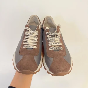 Brunello Cucinelli sneakers brun/grå - Snygga sneakers från Brunello Cucinelli i brunt och grått med detaljer i mocka och textil. Skorna har vita snören med svart text, grov mönstrad sula och rund tå. Tillverkade i Italien, perfekt för dig som gillar exklusiv och stilren design. Ordinary price 5000