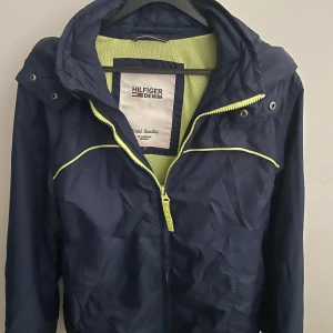 Marinblå vindjacka från Hilfiger Denim - Snygg marinblå vindjacka från Hilfiger Denim i storlek S, modellen är ca 180cm lång. Hör av dig vid funderingar!