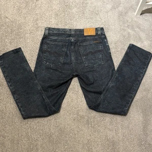 Mörkblå jeans från Nudie Jeans - Nudie jeans i riktigt fet färg o go slim fit passform. Utmärkt skick. Hör av dig om du har frågor, vill du ha fler bilder eller mått.📏 Pris kan gå ner vid snabbt köp! Storlek W31 L32