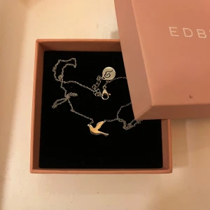 Silverhalsband från Edblad  - Snyggt halsband från Edblad med en tunn silverkedja och en gullig fågelberlock. I rostfritt stål, nyskick.😊 Levereras i original ask.
