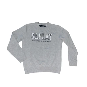 Replay sweatshirt  - Snygg grå sweatshirt från Replay med broderad logga framtill i vitt och svart. Tröjan har rund halsringning, långa ärmar och ribbade muddar vid ärmslut och nederkant. Perfekt för en avslappnad och stilren look. Jag tycker den är liten/krympt i storleken och motsvarar M istället för L som det är på ettiketen men kolla måtten noggrant för säkerhetsskull :) OBS tröjan har en del nopper, skriv för tydligare bild !