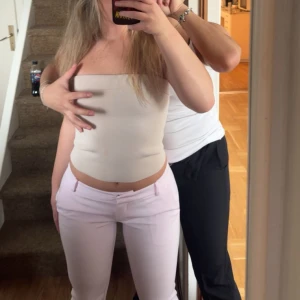 Ljusrosa slim kostymbyxor - Säljer ett par ljusrosa kostymbyxor med slim passform och låg midja. Byxorna har klassiska fickor fram och hällor för bälte. Perfekta för dig som vill ha en fräsch och stilren look med en feminin touch.