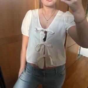 Vit blus med knyt fram - Säljer en söt vit blus med tre knyt framtill och puffiga korta ärmar. Storlek 36 🤍