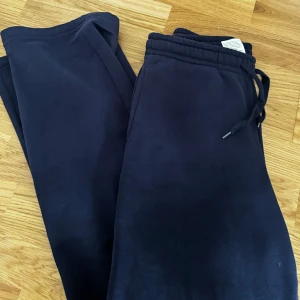 Mörkblå mjukisbyxor från Gina Tricot - Mörkblå mjukisbyxor från Gina Tricot, basically basics-kollektionen. Byxorna har resår och snörning i midjan samt muddar vid bensluten. Perfekta för chill dagar eller när du vill vara extra bekväm. Knappt använd, säljes pga för stora o långa