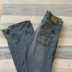 Nudie Jeans Regular Ralf 30/32  - Säljer ett par klassiska blå Nudie Jeans Regular Ralf i storlek 30/32. Fint skick, mycket snygga slitningar/wash. Skriv vid funderingar!