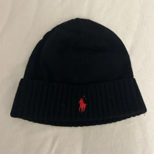 Svart mössa från Polo Ralph Lauren - Säljer en svart mössa från polo Ralph Lauren med röd logga. Nypris 700-1000kr. Hör gärna av er vid funderingar.