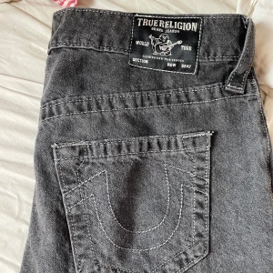 Svarta/grå wide jeans från True Religion - Säljer ett par svarta jeans från True Religion nästan aldrig använda och jätte snygga till hösten. Storlek W27