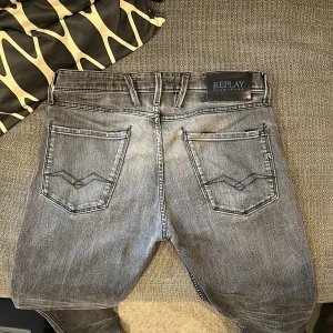Replay ambass jeans - Säljer ett par grå jeans från Replay i ekologisk bomull. Jeansen har klassisk femficksdesign, snygga slitningar och Replay-logga på fickan. Passar dig som gillar en stilren och avslappnad look. Perfekta till sneakers och hoodie.