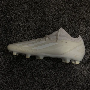 Adidas Crazyfast fotbollsskor - Säljer ett par Adidas Crazyfast fotbollsskor i helvitt med klassiska tre ränder på sidan. Skorna har snörning, rund tå och platt sula med fasta dobbar. Köpte i fel storlek så har bara använt ett par gånger för prov.