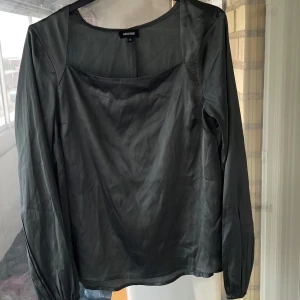 Grön blus med fyrkantig ringning - Stilren grön  blus från Sinsay med lång ärm och fyrkantig ringning. 