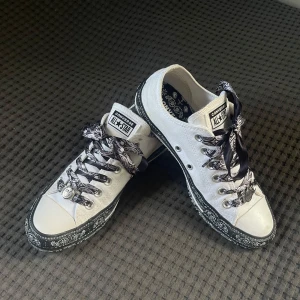 Converse X Miley Cyrus Chuck Taylor All Star - Säljer ett par vita Converse All Star sneakers med ett svartvitt mönster runt sulan och på insidan. Endast använda någon enstaka gång. Storlek EUR 37,5. 24cm invändigt. Passar även mig som har storlek 38 i vanliga fall. Tillverkade i canvas med gummisula. Perfekt för dig som vill sticka ut med detaljer.