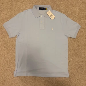 Ljusblå pikétröja från Ralph Lauren - Snygg ljusblå pikétröja från Polo Ralph Lauren i storlek M