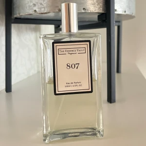 The Essence Vault 807 EdP 100ml - Fräsch och blommig Eau de Parfum med noter av apelsinblom, bergamott, tuberos, indisk jasmin, vanilj, vit musk och Virginia ceder. Volym: 100ml. Perfekt för dig som gillar unika och moderna dofter. Essence valut är engelska motsvarigheten till Essnce. - återstående mängd ser ni i bilderna, ganska exakt halva flaskan kvar