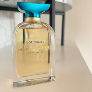 Moroccanoil Eau de Parfum 60 ml  - Moroccanoil L'Originale Eau de Parfum – deras original scent och senaste släpp. Knappt använd, återstående mängd syns i bilden. (ord.pris ligger mellan 879-1099kr)  Doftnoterna: i Toppen: Söt viol, blomman kamelia, mjuk citrus  Hjärta: Frisk liljekonvalj, sammetslena träslag, skir vanilj  Bas: Vitt sandelträ, eterisk mysk, kryddig bärnsten