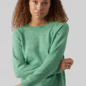 Grön stickad tröja med rund hals - Mysig grön stickad tröja med rund halsringning och ribbade muddar vid ärmslut och nederkant. Tröjan har en enkel och stilren design, perfekt att slänga på sig när det är kyligt ute. Långärmad och i mjukt material som känns skönt mot huden. Lite nipprig men inget man lägger märke till❤️