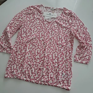 Blommig blus från Tom Tailor, S - Söt blus från Tom Tailor i vitt med rosa blommigt mönster. Blusen har v-ringning och trekvartsärm. Tillverkad i en mjuk mix av bomull och modal som känns skön mot huden. Perfekt för dig som gillar en feminin och fräsch stil.