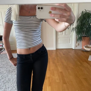Randig croppad topp med fyrkantig ringning - Säljer en vit och svart randig croppad topp med fyrkantig ringning och korta ärmar. Toppen är ribbad och sitter tight, perfekt till jeans eller kjol. Superenkel att styla!