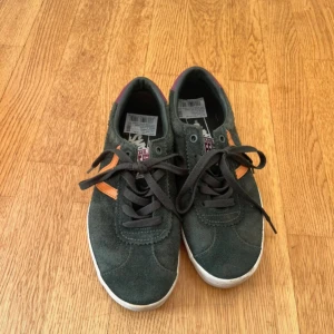 Vans Sport Low sneakers i mocka - Snygga Vans Sport Low sneakers i mörkgrön mocka med lila detalj på hälen och orange V-logga på sidan. De är knappt använda då de var för små när de köptes.