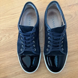 Mörkblå sneakers från Lanvin - Hej 👋 jag säljer mina lanvins som fortfarande är i väldigt bra skick typ 8/10  inga defekter osv. Tyvärr ingår inget annat än skorna. Självklart äkta skriv vid fundering! Uk 10 som motsvarar 45
