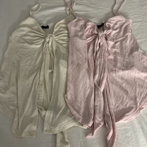 Toppar  - Två snygga omlottoppar från Gina Tricot i storlek XS. En är ljusbeige och den andra ljusrosa, båda med smala axelband och långa knytband framtill. Köp båda tillsammans 50kr eller en var för sig för 35kr🥰