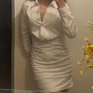 Vit klänning  - En vit klänning, går ner till knän. Ganska tajt.