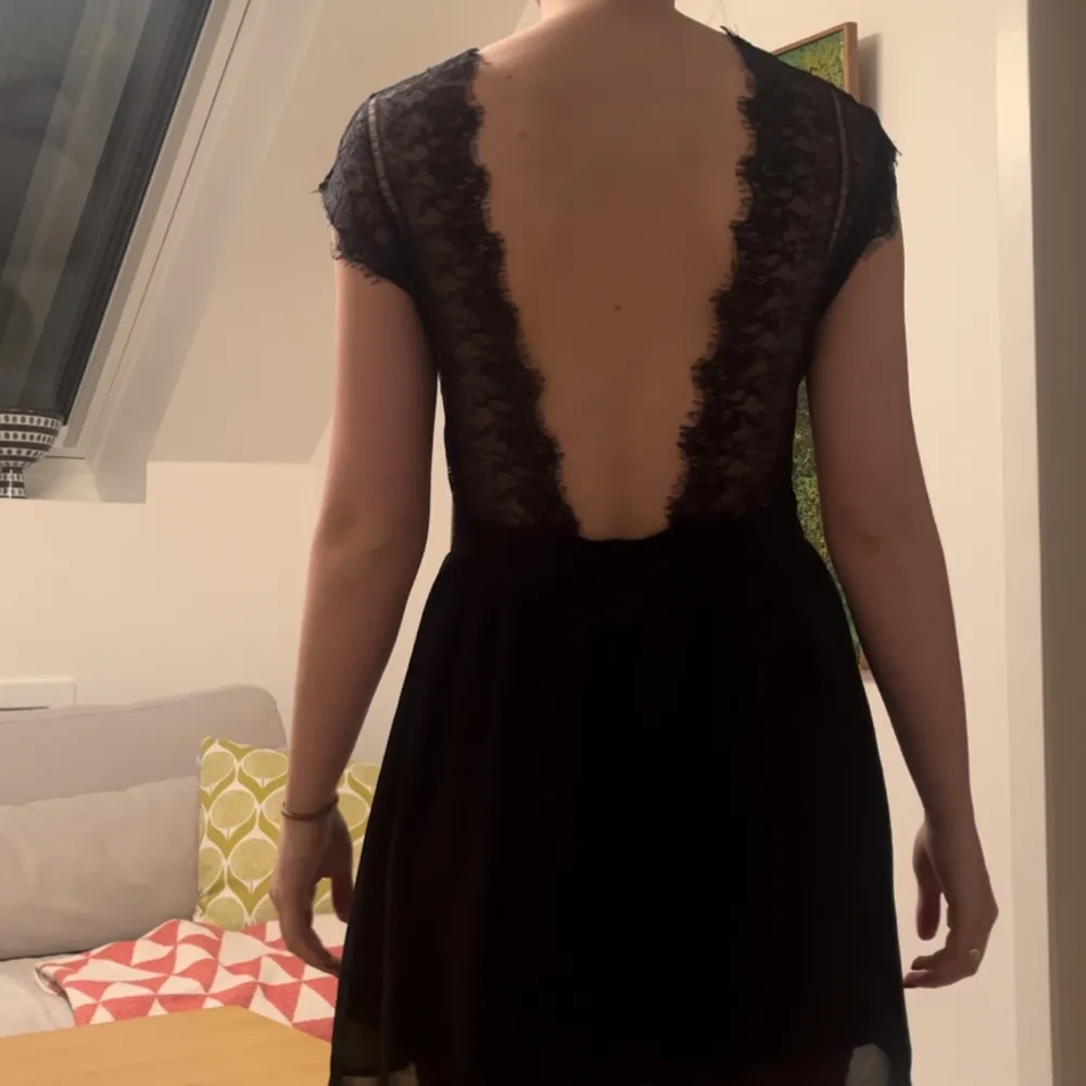 Fin svart klänning med en låg rygg med spetskant. Klänningen är i väldigt fint skick i storlek M men sitter bra på mig som brukar pendla mellan S och M. . Klänningar.