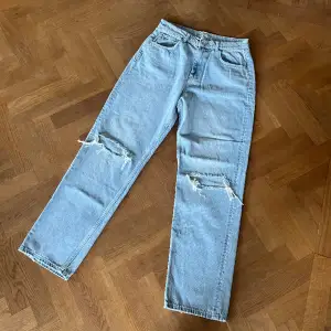 Jättefina oanvända Gina Tricot jeans. Jeansen är i en ljusblå tvätt med hål på båda knäna. Storlek 42.🩵