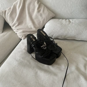 Platåklackar med långa band  - Svarta klackar använda enbart en gång. Storlek 39.