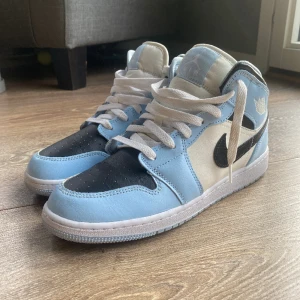 Jordan 1 Mid Ice Blue - Äkta Jordan 1 Mid Ice Blue i storlek 40. Mycket gott skick, använda 2-3 ggr. Creaseade något men inget märkvärdigt. Digitalt kvitto finns. Köpta i Stockholm. Nypris 2399kr, mitt pris 1800kr