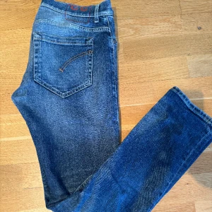 Dondup jeans - Säljer mina Dondup George slim fit jeans då de blivit för små för mig. De är inköpta på NK Göteborg och har storlek 33. Kvaliten är 7/10 och jeansen har inga märken eller synliga slitage. Var inte rädd att höra av er om ni har några frågor! 