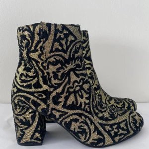 AOP guld stövletter  - Stövletter i vackert mönster i guldtråd passar perfekt till en utekväll på hösten. Säljer pga för små för mig