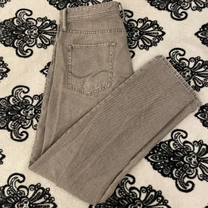 Grå jeans  - Gråa Jack & Jones jeans i mycket bra skick! Modell Chris. Inga defekter någonstans och de är mycket sparsamt använda.  Storlek 33/36 men längden sitter precis som ett par jeans i 34.  Pris kan diskuteras vid snabb affär.  