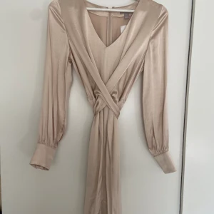 Fin satängklänning - Mycket fint skick! Aldrig använd. Omlott och knytes i ryggen. Fint fall.