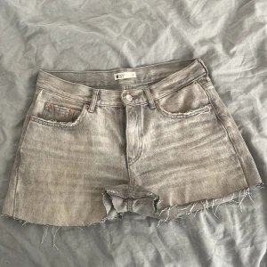 Grå jeansshorts  - Säljer dessa skitsnygga gråa jeansshorts som från en början är ett par jeans. Små slitningar på sömmen vid skrevet.