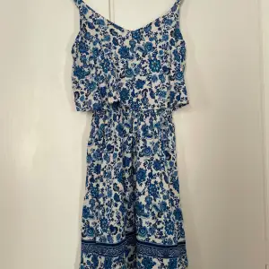 Vit/blå gullig klänning med blommiga detaljer på. Säljer då den är för liten. Knappt använd då väldigt bra skick. 