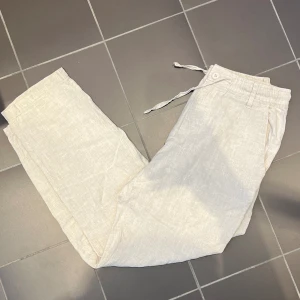 Linnebyxor - Beiga linnebyxor av 100% linne från Akryl. Går att ha skärp. Regular fit. Ny pris 700 kr, säljer de för 400kr. Köparen står för frakten 